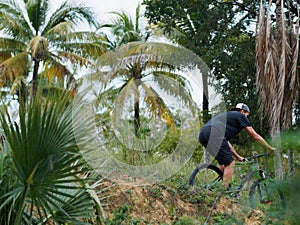 Mountain Biker Riding Through The Jungle. Tropical island.