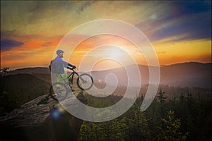 Mountain biker riding at sunset on bike in summer mountains fore