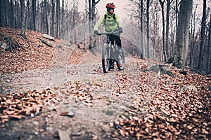 Mountain biker riding on trail in autumn woods