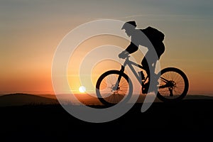 Mountain biker silhouette in sunrise, active lifestyle concept