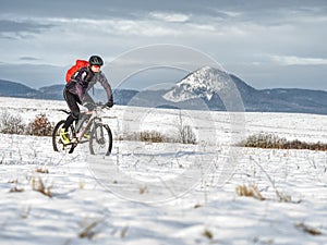 Mountain biker in snowy landscape. Sportsman ridding in snow