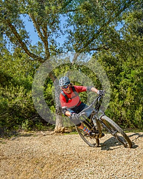 Mountain biker takes a turn at an angle and in a professional position. Sporty and dynamic image that reproduces enduro