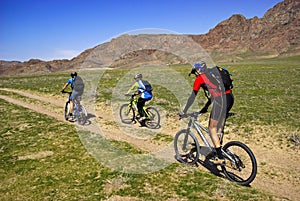 Mountain bikers on old road in steppe