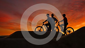Mountain bikers outdoors riding at sunset