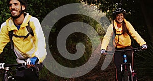 Mountain biking couple riding in the forest on a sunny day