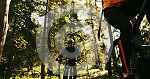 Mountain biking couple riding in the forest on a sunny day