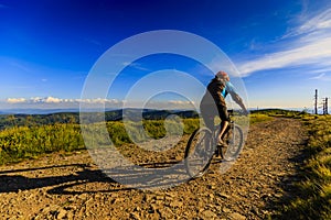 Mountain biking cycling at sunset in summer mountains forest lan