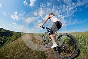 Mountain biking happy sportive girl relax in meadows sunny countryside