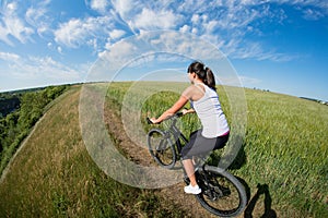 Mountain biking happy sportive girl relax in meadows sunny countryside