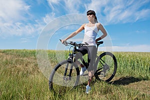 Mountain biking happy sportive girl relax in meadows sunny countryside