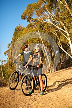 Mountain biking is by nature a pretty adventurous sport. a young couple out mountain biking.