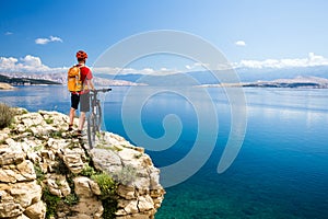 Mountain biking rider looking at inspiring sea and mountains