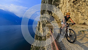 Mountain biking at sunrise woman over Lake Garda