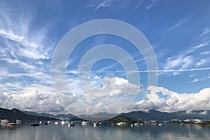 Mountain, blue sky, boats, yacht and sailboats on lake