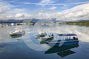 Mountain, blue sky, boats, yacht and sailboats on lake