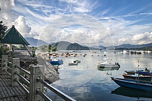 Mountain, blue sky, boats, yacht and sailboats on lake