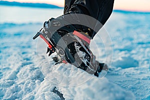 Mountain Boot with crampons on while hiking in the mountains in winter.
