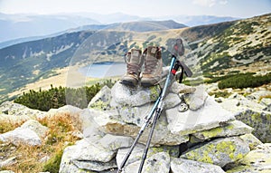 Mountain boots and trekking sticks on mountain peak