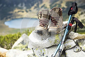 Mountain boots and trekking sticks on mountain peak