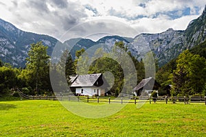 Mountain cabins in the region of Ukanc near the Lake Bohinj in the Triglav National Park in Slovenia on summer day with clouds