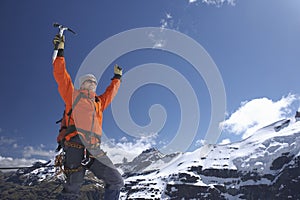 Mountain Climber With Arms Raised Against Snowy Mountains