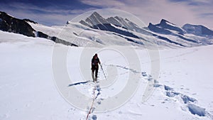 Mountain climber on a large glacier in the Alps with a great view behind him