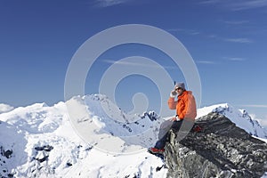 Mountain climber using walkie-talkie on mountain peak