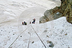 Mountain climbers with ropes on snow