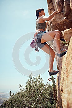 Mountain, climbing and sport with a sports woman or athlete abseiling outdoor for health and fitness. Training, workout