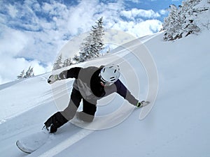 Mountain with clouds and snow, snowboarder in full speed