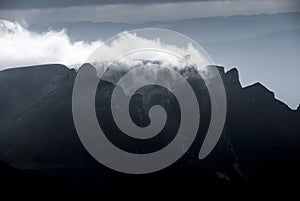 Mountain clouds at sunset, above high peaks
