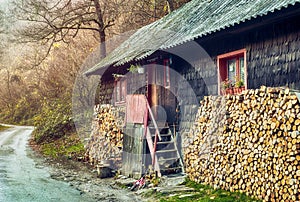 Mountain cottage of wood with pile of firewood