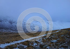 Mountain covered with snow in fog and a lonely path in the Isle Arran, Scotland