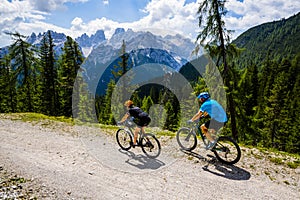 Mountain cycling couple with bikes on track.