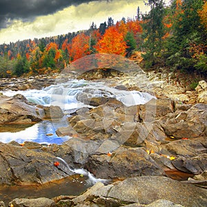 Mountain fast flowing river stream of water in the rocks at autumn