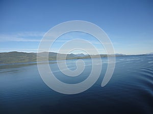 Mountain Filled horizon on the pacific ocean. Inside passage Alaska under a cloudy sky