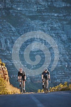 Mountain, fitness and male athletes cycling on bicycles training for a race or marathon in nature. Sports, workout and