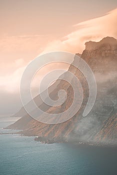 Mountain, fog and ocean landscape with cliff, cloudy sky and tropical island sunset for travel location. Nature, sea and