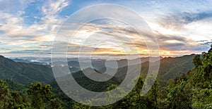 Mountain forest landscape under sunrise sky with clouds