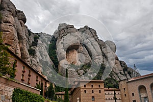 Mountain formations and abbey of Montserrat at a dark cloudy day photo