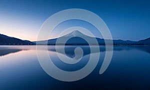 Mountain Fuji at dawn with peaceful lake reflection