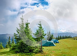 Mountain glade and two hiking tents in Carpathians after rain