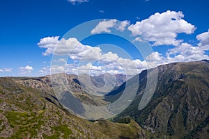 Mountain gorge landscape with cloudy blue sky. Summer nature landscape. River valley panorama. Kora river gorge in Kazakhstan, way