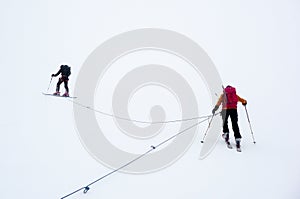 Mountain guide and clients on a glacier during a whiteout