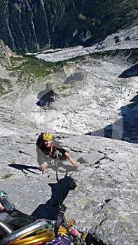 Mountain guide on a hard granite climb to a high alpine peak in the Swiss Alps