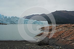 A mountain guide helps ice trekking tourists on Perito Moreno Glacier in the Los Glaciares National Park