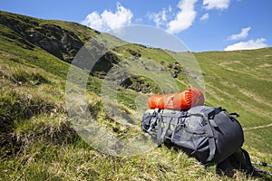 Mountain hiking backpack equipment on the grass with mountain la