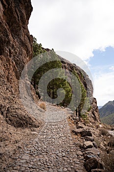 Mountain hiking trail leading into a mountain. Rocky path on the side of a mountain in Gran Canaria, Spain