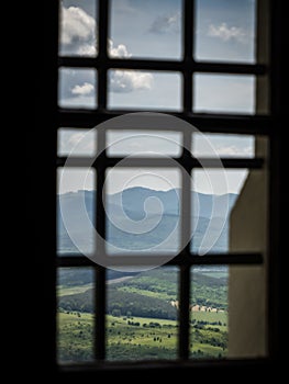 Mountain hills view from a barred castle window