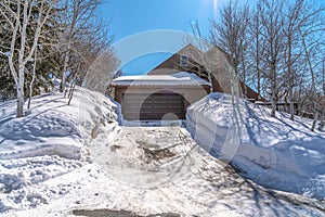 Mountain home in Park City Utah with snowy driveway leading to gray garage door